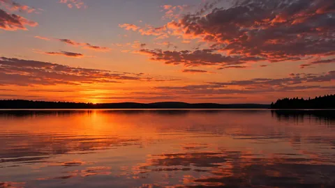 Editorial illustration of orange and pink sunset clouds reflected in a quiet lake.